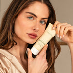 Model with blue eyes and brown hair holding Anare Naturals gentle exfoliator, showcasing the product.