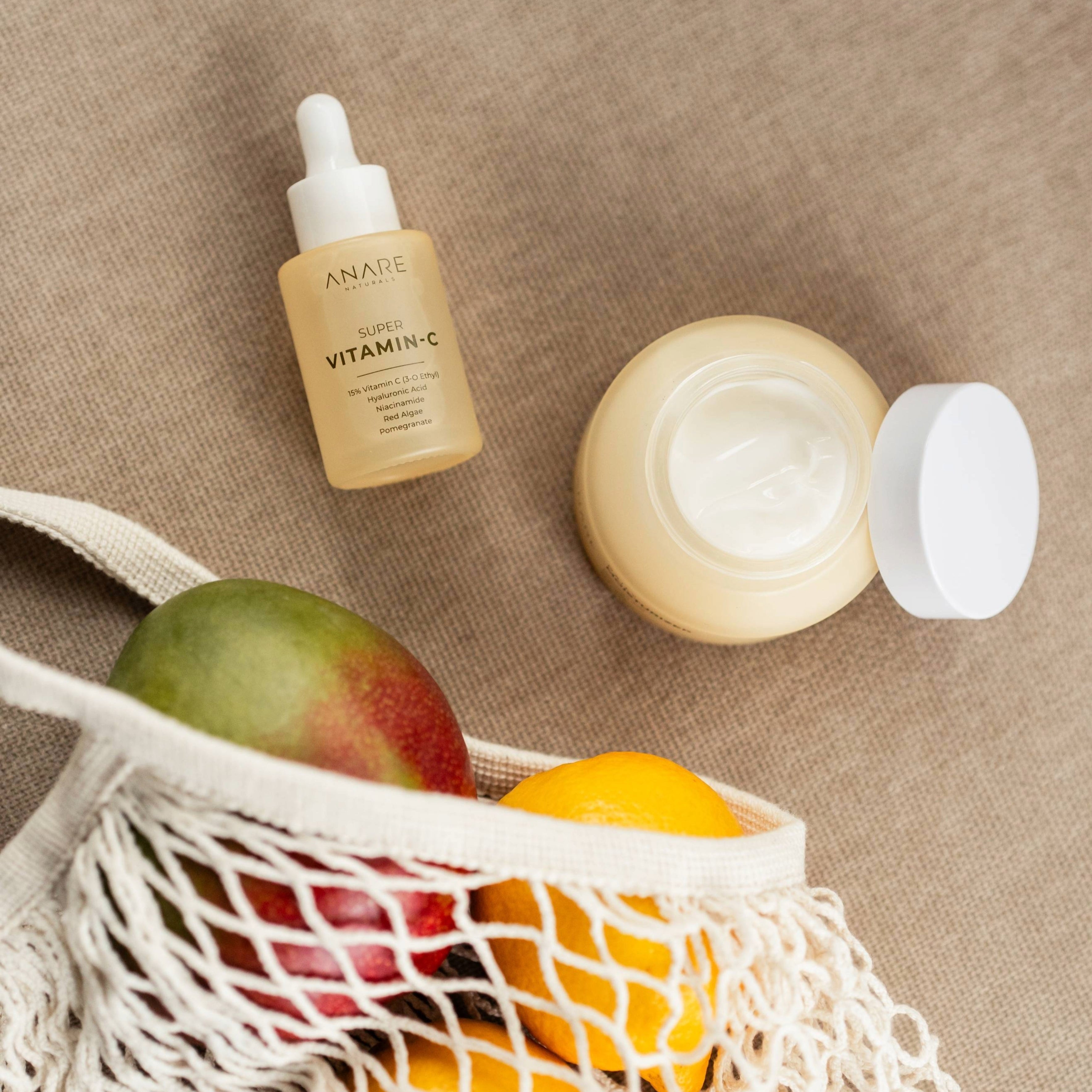 Hydrate & Glow bundle with Super Vitamin C Serum and Daily Moisturizer placed alongside mangos and lemons, emphasizing natural ingredients, vitamins, and daily self-care essentials.